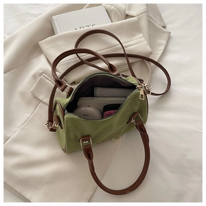 Interior view showing the capacity of a green suede Boston bag with daily essentials