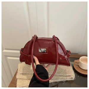 Close-up of vintage burgundy patent leather underarm bag with silver metallic hardware details
