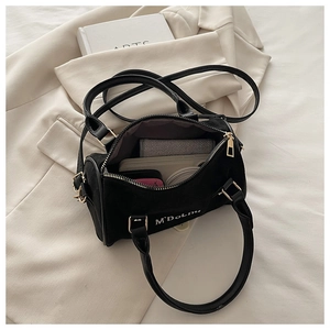 Detail of black suede Boston bag showing spacious interior for wallet and cosmetics