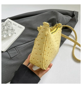 Detail of yellow ostrich texture hobo bag with gold zipper and thin shoulder strap