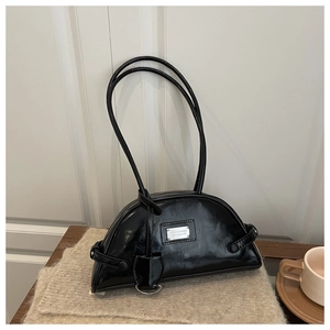 Close-up of black crescent shoulder bag in glossy oil-wax leather with metal logo