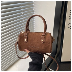 Close-up of brown frosted leather Boston bag with embossed logo and gold hardware