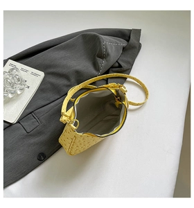 Detail view of yellow ostrich texture shoulder bag with golden zipper and inner lining