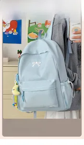 Close-up of light blue backpack with bow embroidery and yellow moon plush charm