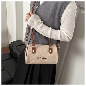 Detail of suede Boston bag with brown leather handles and brand logo embroidery