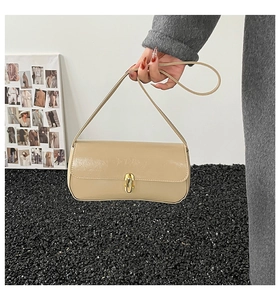 Detail der beigen Baguette-Tasche aus Faltenleder mit goldenem Drehverschluss-Verschluss