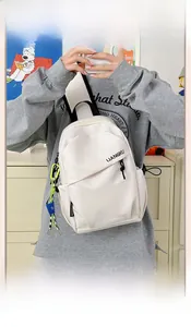 Détail du sac à dos minimaliste en nylon blanc cassé avec lettrage de marque sur le devant