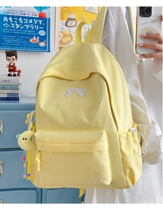 Detail of yellow nylon backpack with bow pattern and moon plush charm decoration