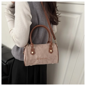 Detail of khaki suede Boston bag with brown leather handles and M'DOLNU embroidery