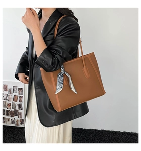 Detailed side view of brown lychee grain tote bag with silk scarf on shoulder