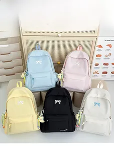 Detail of macaron-colored backpacks with bow embroidery and crescent moon pendants
