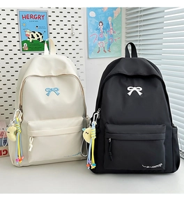Close-up of minimalist canvas backpack featuring bow embroidery and soft moon pendant