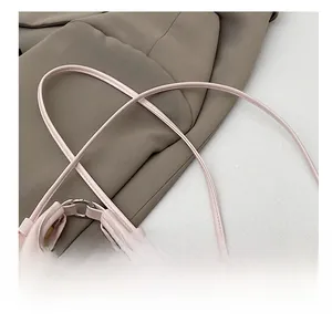 Detail of pink leather handbag with fine shoulder strap and silver metal buckle