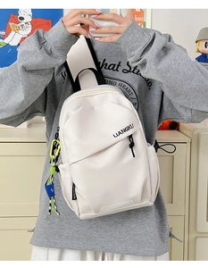 Détail du sac à dos en nylon blanc crème avec pendentif coloré et sangle mode