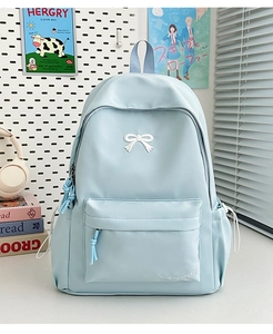 Detailed view of light blue school backpack featuring bow embroidery and side pockets