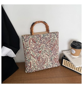 Detail of vintage purple floral jacquard canvas bag with natural bamboo handles