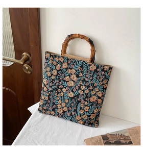 Detailed view of the woven floral fabric texture and natural bamboo handle of the tote bag