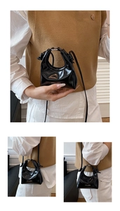 Macro shot showing glossy black patent leather texture and white logo branding on small bag