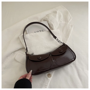 Détail d'un sac d'épaule rétro marron foncé avec doubles poches et chaîne métallique