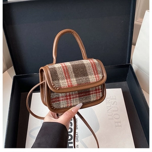 Detail of vintage plaid mini crossbody bag with leather trim and round top handle