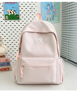 Close-up of light pink nylon backpack with bow embroidery and multi-pocket design
