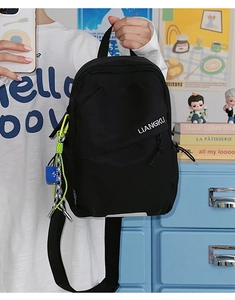 Gros plan d'un sac de poitrine en nylon noir avec logo blanc et cordon vert