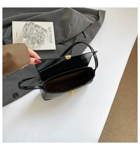 Détail de l'intérieur du sac baguette noir avec doublure brune et fermoir doré