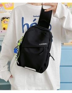 Détail du sac de poitrine minimaliste en nylon noir avec logo et cordon jaune décoratif