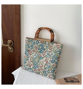 Detail of vintage floral jacquard tote bag featuring premium bamboo top handles