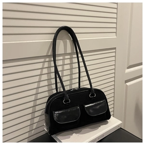 Detail of vintage black baguette bag featuring matte suede and glossy patent leather pockets