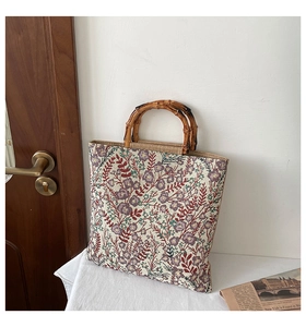 Detailed shot of vintage floral canvas tote bag featuring natural bamboo handles