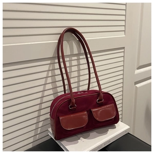 Close-up of retro burgundy shoulder bag featuring dual patent leather pockets and velvet texture