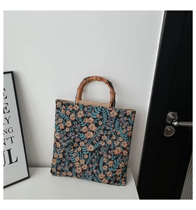 Detail of vintage canvas tote with colorful floral jacquard and natural bamboo handles