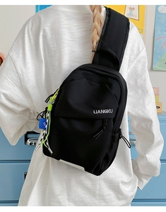 Détail d'un sac de poitrine en nylon noir avec logo et cordons décoratifs fluo
