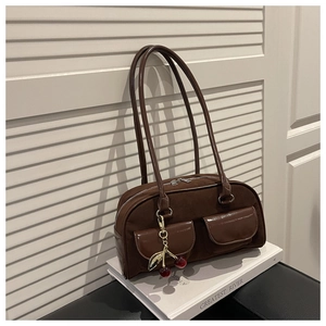 Detail of vintage brown suede Boston bag with double pockets and cherry charm