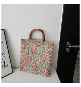 Detail of floral jacquard fabric and natural dark bamboo handle on a tote bag
