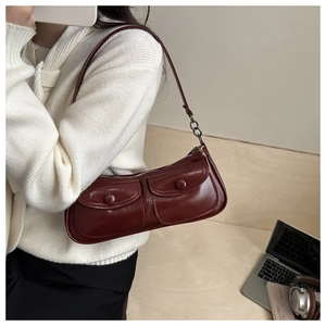 Détail du sac à main rétro en cuir bordeaux avec boutons vintage et double poche frontale