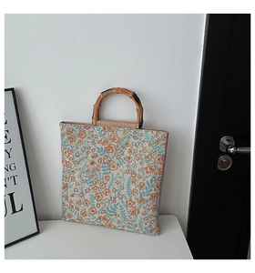 Detailed close-up of a floral jacquard canvas tote with a natural bamboo handle