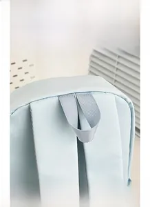 Detail of light blue backpack featuring durable nylon fabric and reinforced top handle