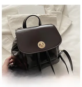 Detail of dark brown leather backpack featuring a vintage gold roman numeral twist lock