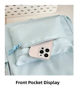Close-up of the front pocket of a light blue nylon backpack showing storage capacity