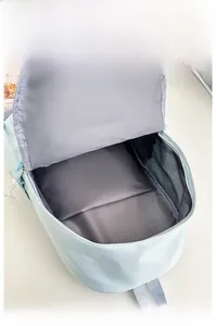 Internal storage view of light blue nylon backpack showing deep main compartment and lining