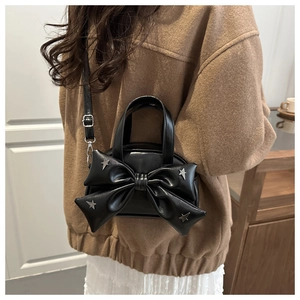 Détail du sac seau à nœud noir avec rivets étoiles argentés et cuir PU brillant