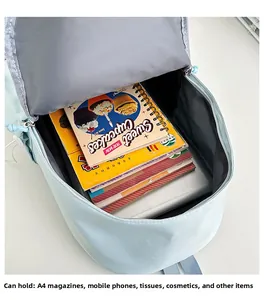 Spacious main compartment of light blue nylon backpack holding laptop and A4 magazines