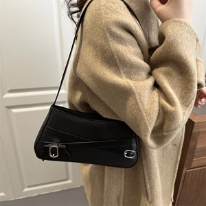 Vintage black faux leather underarm bag with bow detail and silver buckles on ivory coat