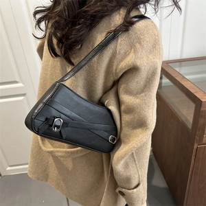 Minimalist black leather underarm bag with decorative silver buckles and cross straps