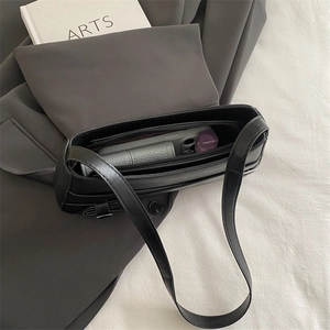 Minimalist black leather underarm bag with spacious interior for daily essentials