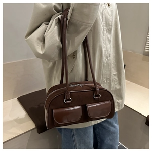 Detail of vintage dark brown baguette bag with dual front pockets and mixed leather textures
