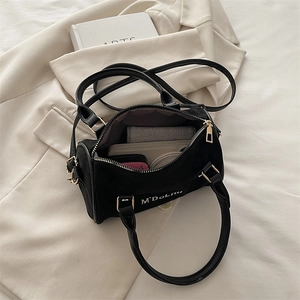 Black frosted Boston bag with large interior capacity on a beige blazer