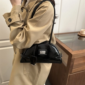 Glossy black patent leather crescent shoulder bag with silver metal plaque detail